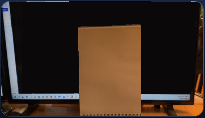 A sketchbook placed in front of the monitor to hide the screen area where the target image appears.